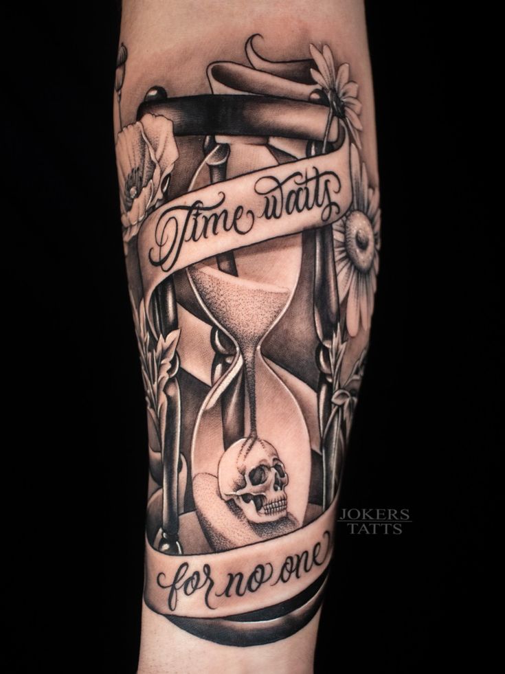 a black and white tattoo with an hourglass, skull and ribbon on it's arm