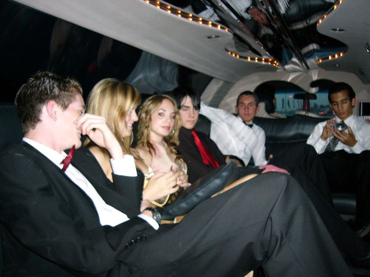 a group of people sitting in the back of a limo on a night time trip