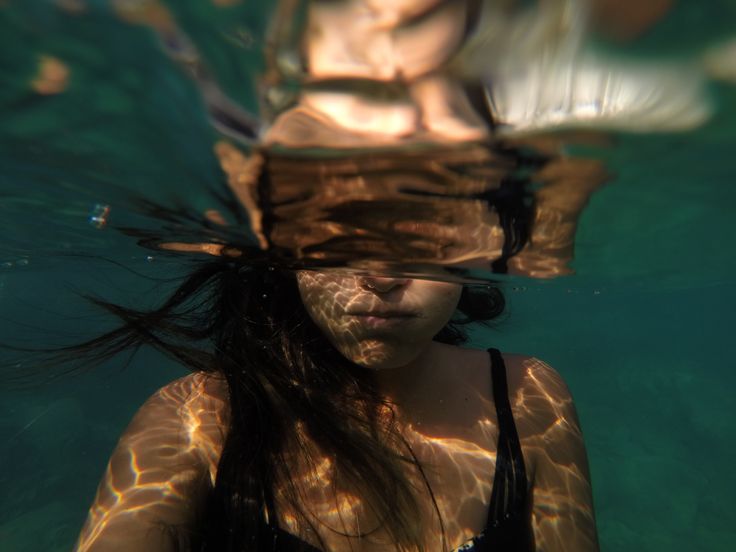 a woman with long hair swimming in the water