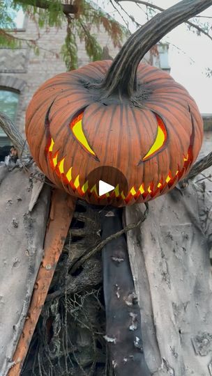 a carved pumpkin sitting on top of a pile of wood