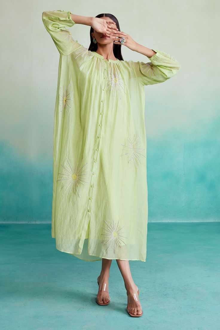 Lime oversized dress with hand-embroidered sun motifs and pleats around the neck.
Components: 1
Pattern: Hand Embroidered
Type Of Work: Sun
Neckline: Mandarin
Sleeve Type: Three Quarter
Fabric: 40g Chanderi, Lining: Mal
Color: Green
Other Details: 
Full length: 52 inches
Closure: Front button down
Note: Inner worn model is not for sale
Occasion: Work,Party - Aza Fashions Embroidered Sun, Dramatic Sleeves, Oversized Dress, Work Party, Natural Fabrics, Dress For Women, Embroidered Dress, Xl Dress, Aza Fashion