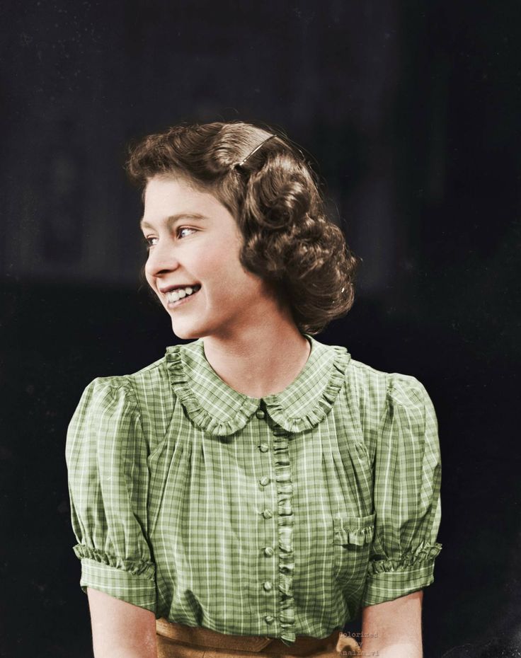 an old black and white photo of a woman smiling