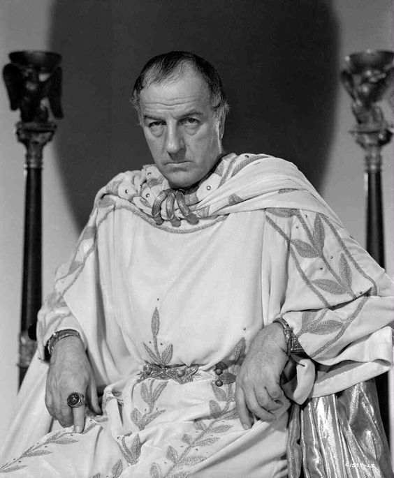 black and white photograph of a man dressed in roman garb sitting on a chair