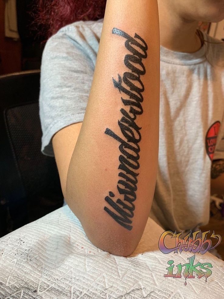 a woman sitting at a table with a tattoo on her arm that reads,'congratulations '