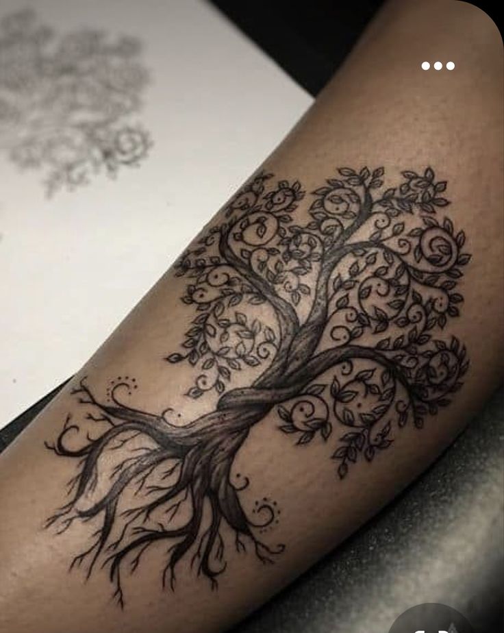 a black and white photo of a tree tattoo