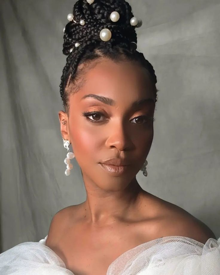 a woman in a white dress with pearls on her head