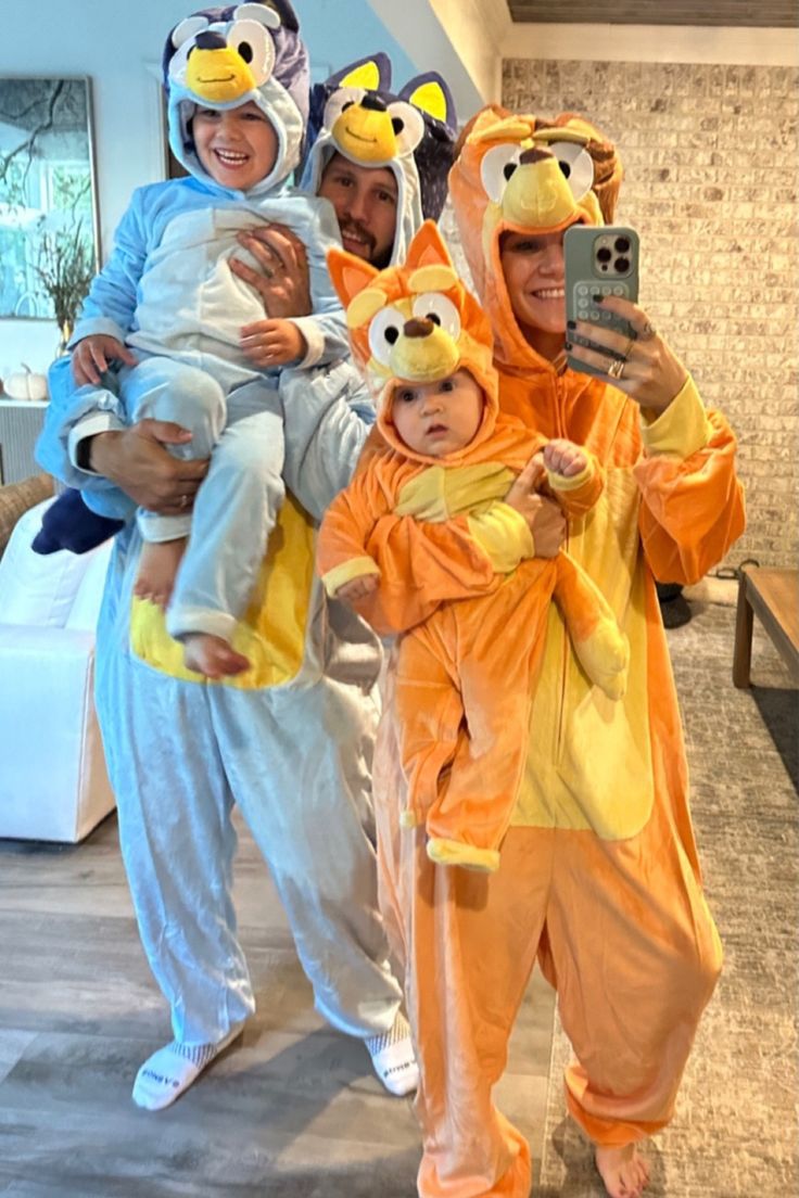 three people in animal onesuits taking a selfie with a baby and an adult