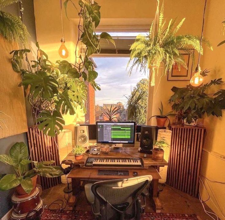 a home office with plants and electronic equipment