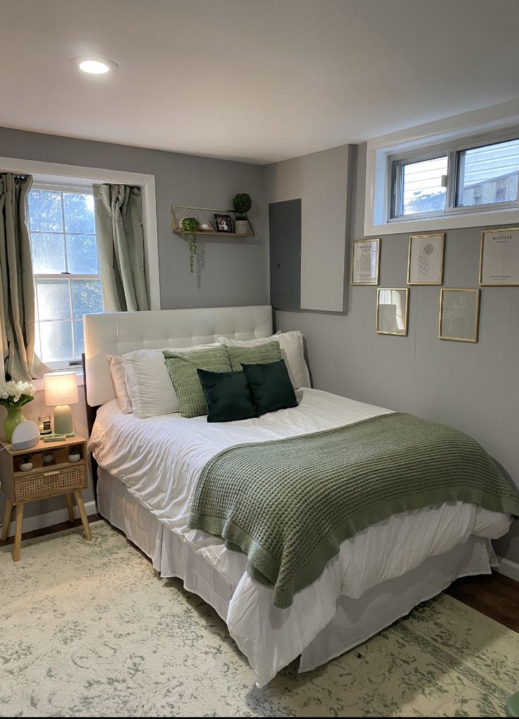 a bed sitting in a bedroom next to a window covered in green and white blankets