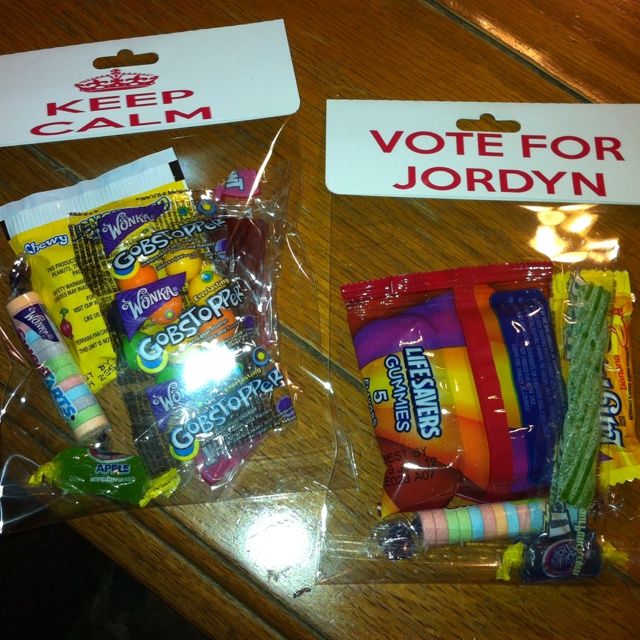 two plastic bags filled with candy and candies on top of a wooden table next to a sign that says keep calm