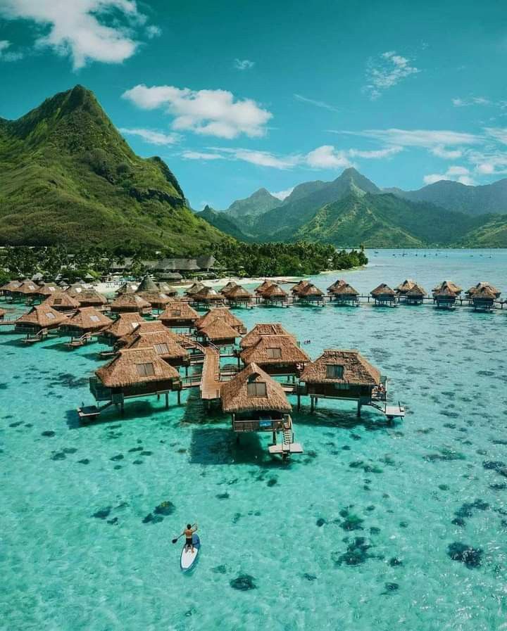 the water is crystal blue and clear with many huts on it's sides that are surrounded by mountains