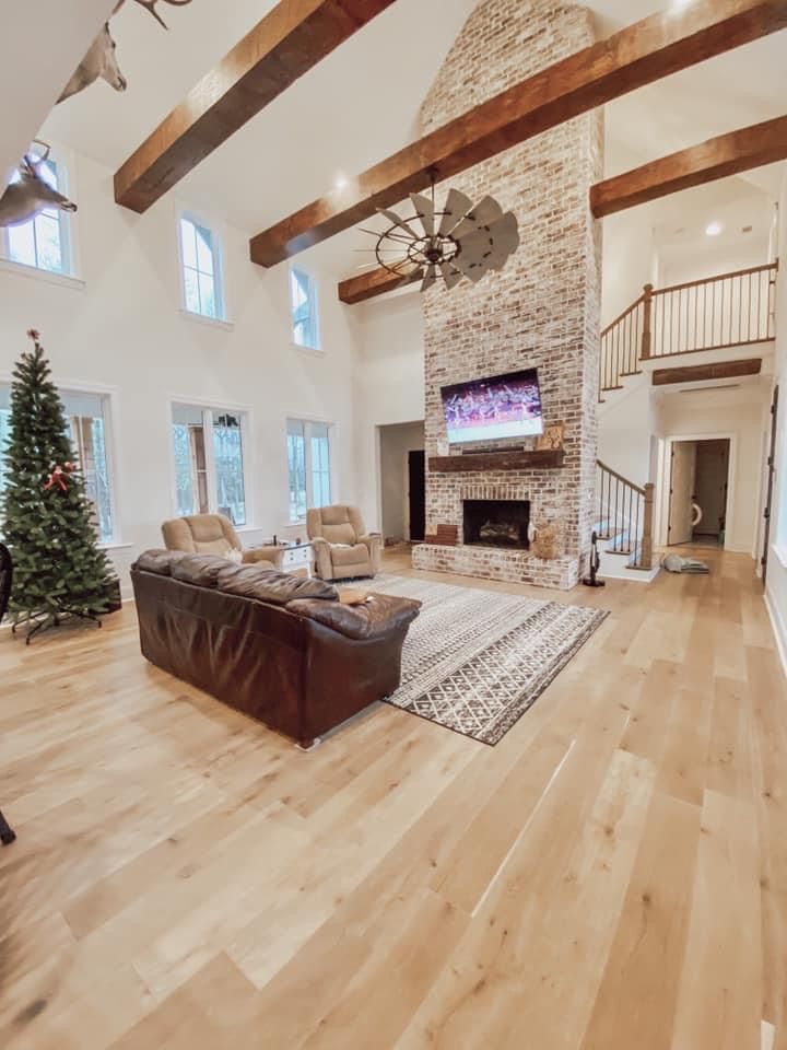 a large living room with wood floors and white walls