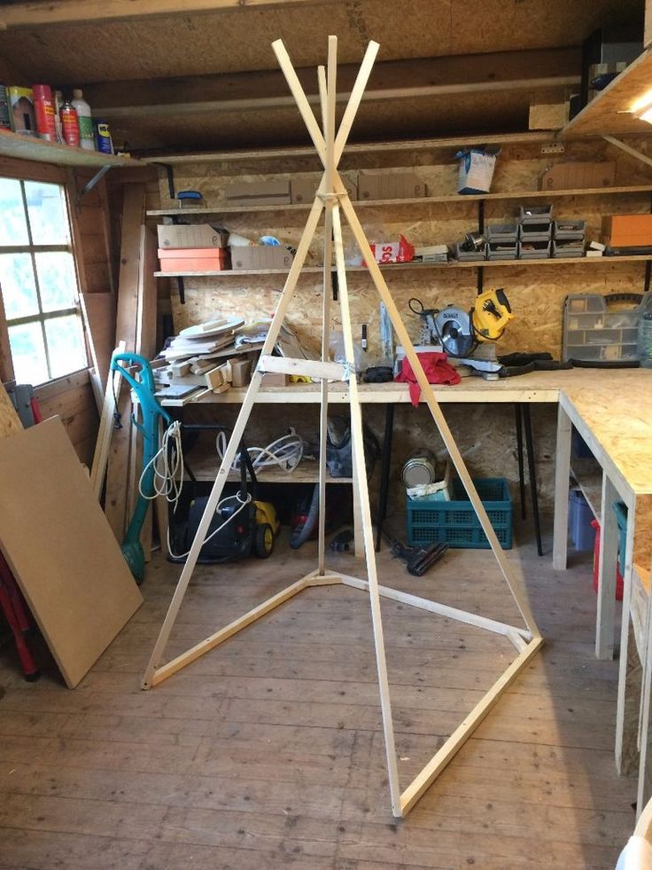 a wooden structure sitting in the middle of a room filled with tools and other items