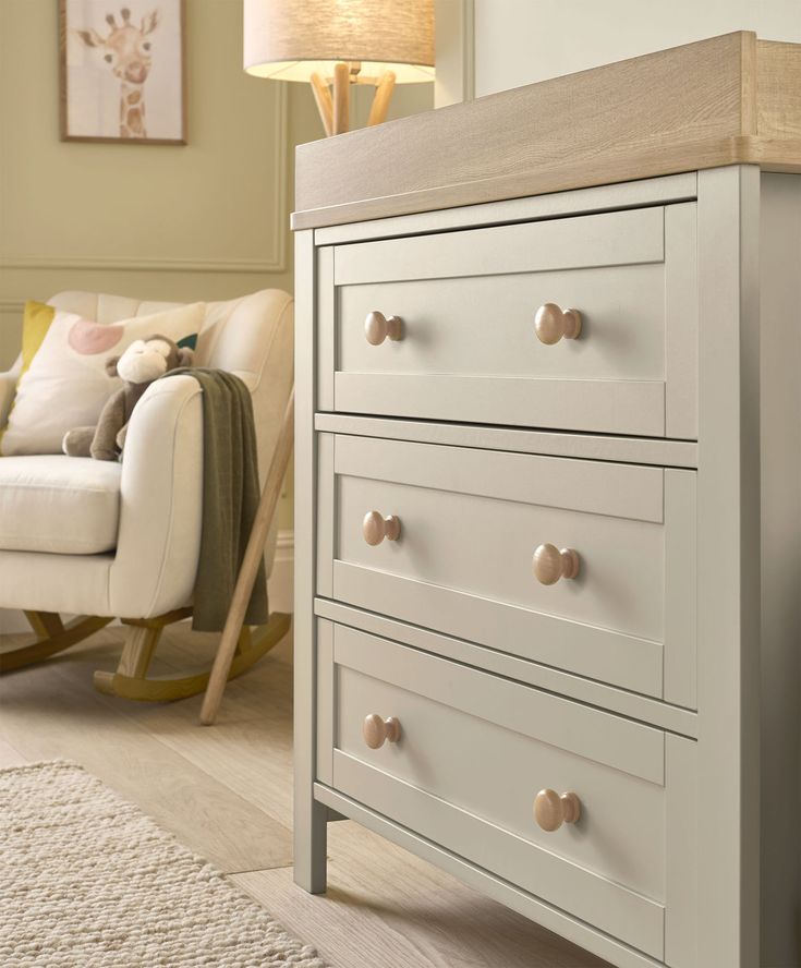 a baby's room with a rocking chair and dresser