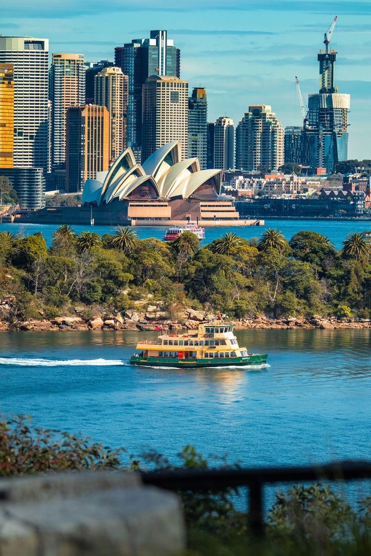 a boat traveling on the water in front of a city