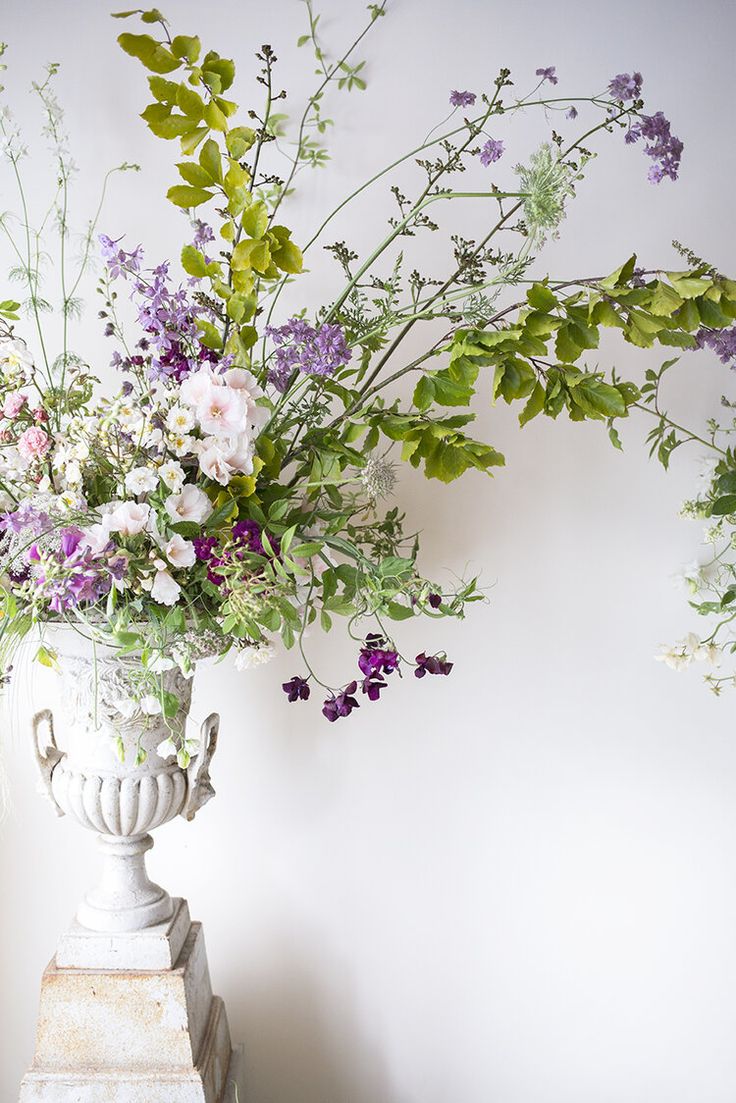 a vase filled with lots of flowers sitting on top of a table