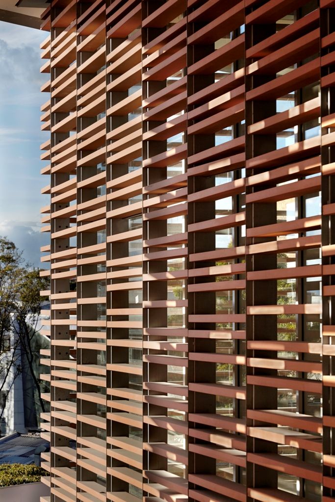 the side of a building with wooden slats on it's sides and trees in the background