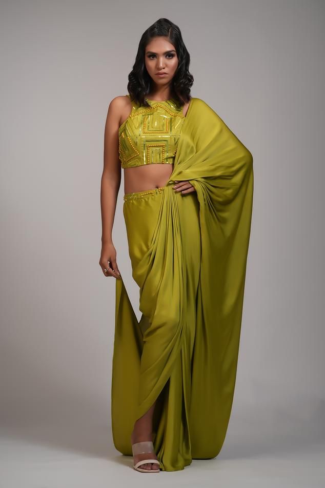 Mustard green pre-draped saree with pearl, sequin embroidery on waistband. Paired with geometric embroidered padded blouse.
Components: 2
Pattern: Embroidery
Type Of Work: Pearl, sequin
Neckline: Round
Sleeve Type: Sleeveless
Fabric: Saree: Modal Satin, Blouse: Silk
Color: Green
Other Details: 
Back deep U neck blouse
Approx weight: 5-7 kgs
Model height: 5ft 9inches, wearing size M
Occasion: Sangeet - Aza Fashions Green Pre-draped Saree With Sheer Dupatta, Green Draped Lehenga For Wedding, Green Draped Saree With Unstitched Blouse, Elegant Draped Green Lehenga, Green Silk Pre-draped Saree For Evening, Green Draped Silk Sets, Festive Green Pre-draped Saree, Green Blouse Piece For Evening With Traditional Drape, Green Draped Lehenga For Festive Occasions