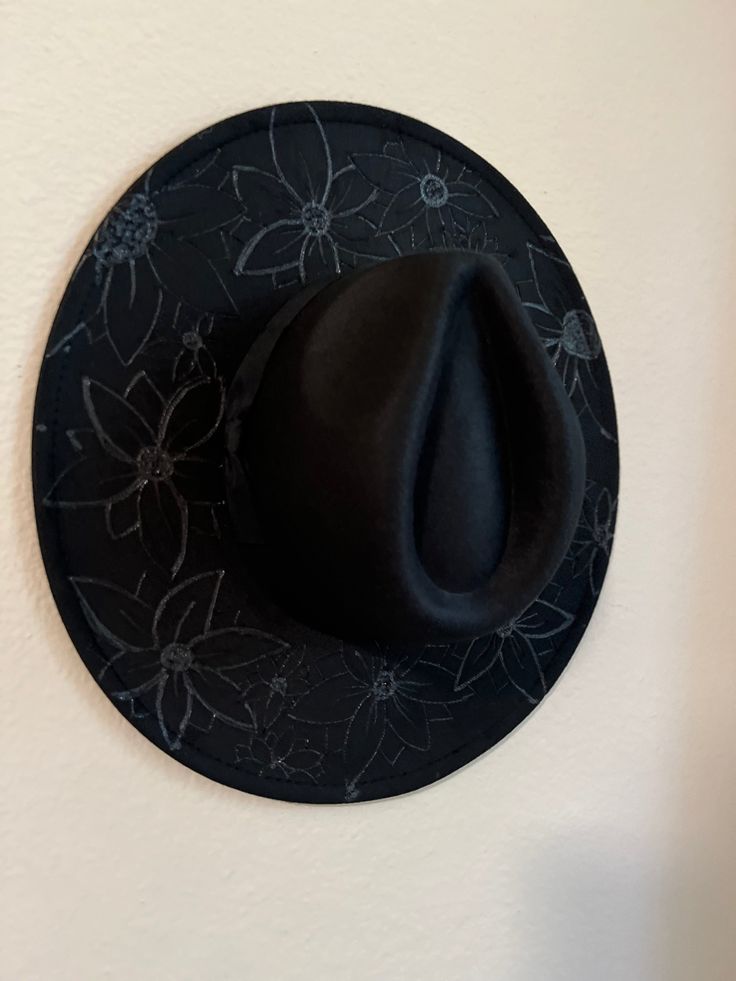 This custom-made black Rancher hat is the perfect way to express yourself. Its wide brim and hand burned flowers provide a subtle, sophisticated look that's unique and eye-catching. Stand out from the crowd with this Black Record custom hat! Get that blind-embossed look with this gorgeous black hat. Handmade Black Fedora With Curved Brim, Handmade Black Felt Hat With Flat Brim, Handmade Black Fedora With Flat Brim, Black Handmade Fedora For Kentucky Derby, Handmade Black Hat For Kentucky Derby, Cowboy Hat Crafts, Rancher Hat, Hat Custom, Black Hat