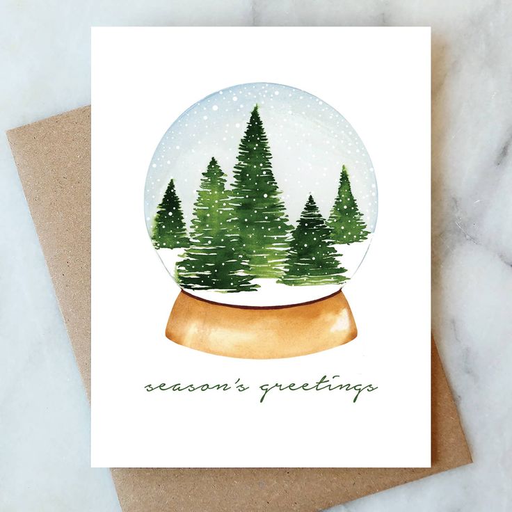 a snow globe with trees inside it on top of a card that says season's greetings