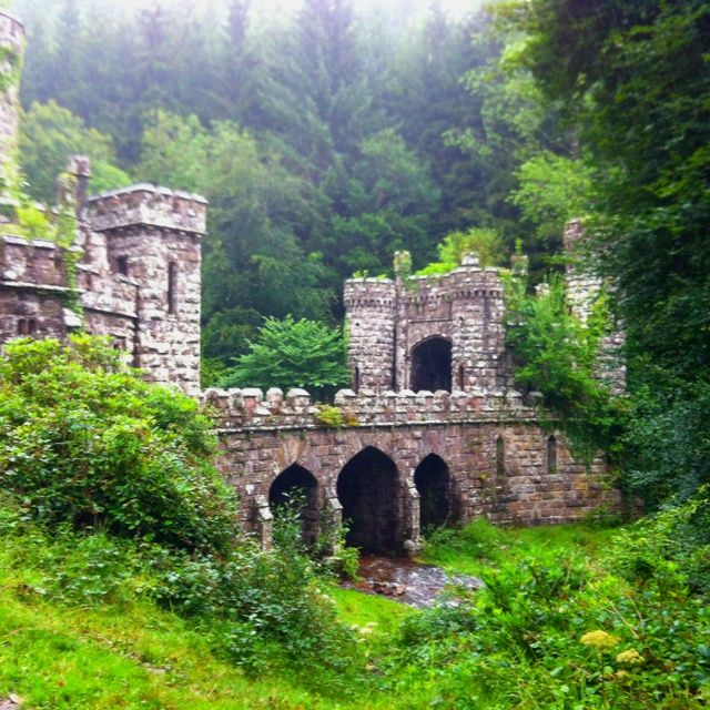 an old stone bridge surrounded by trees and bushes