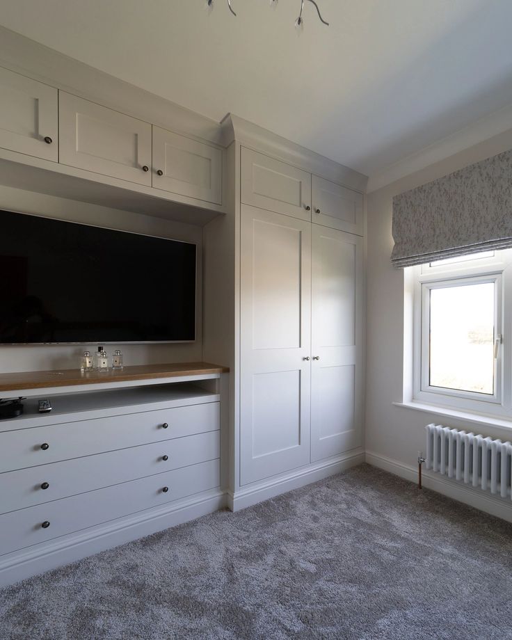 an empty room with white cabinets and a flat screen tv