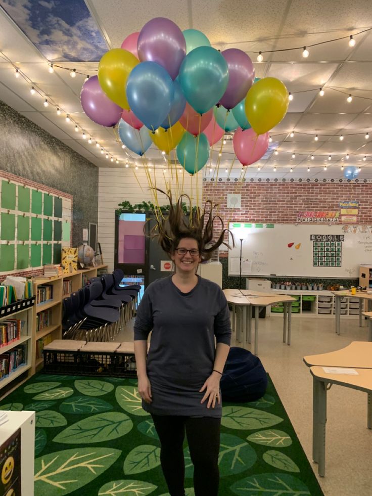 a woman standing in front of a bunch of balloons