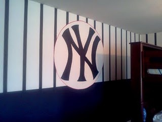 the new york yankees logo is on the wall in this boys'room, which features striped walls and black and white stripes