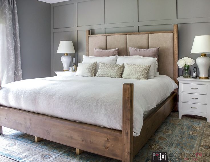 a large bed sitting on top of a wooden floor next to two nightstands and a lamp