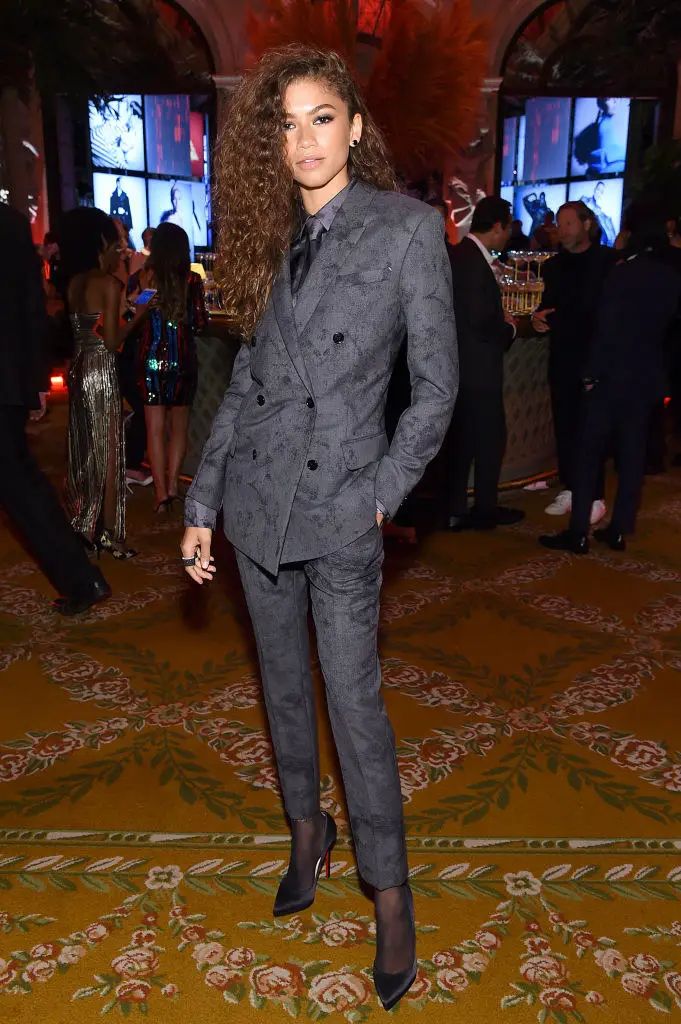 a woman in a suit standing on a carpet