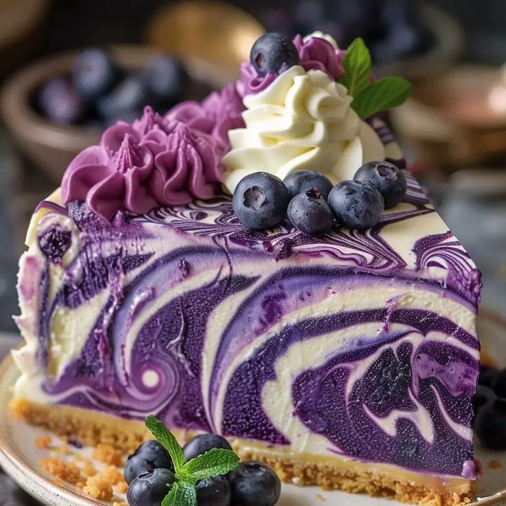 a piece of cheesecake with blueberries and whipped cream on top, sitting on a plate