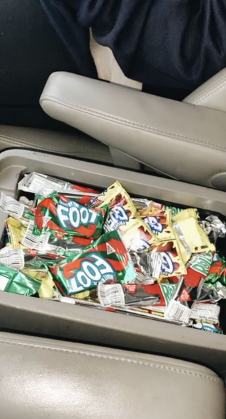 a suitcase filled with lots of candy sitting on top of a seat