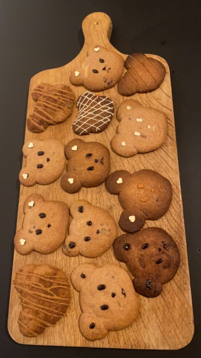 a wooden cutting board topped with lots of cookies