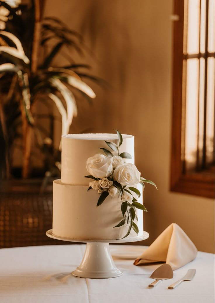 a wedding cake sitting on top of a table next to a white cloth covered tablecloth