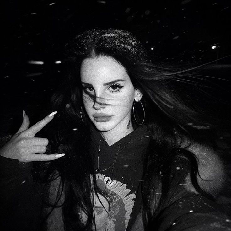 a woman with long hair and piercings making the peace sign in front of her face