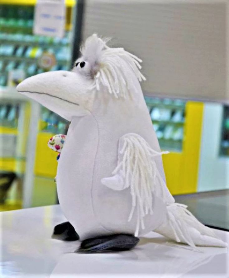 a white stuffed animal sitting on top of a table