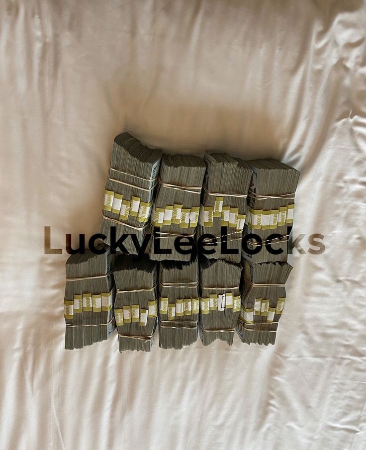 several stacks of money sitting on top of a bed