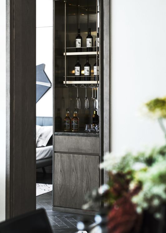 an open cabinet with bottles and glasses in it