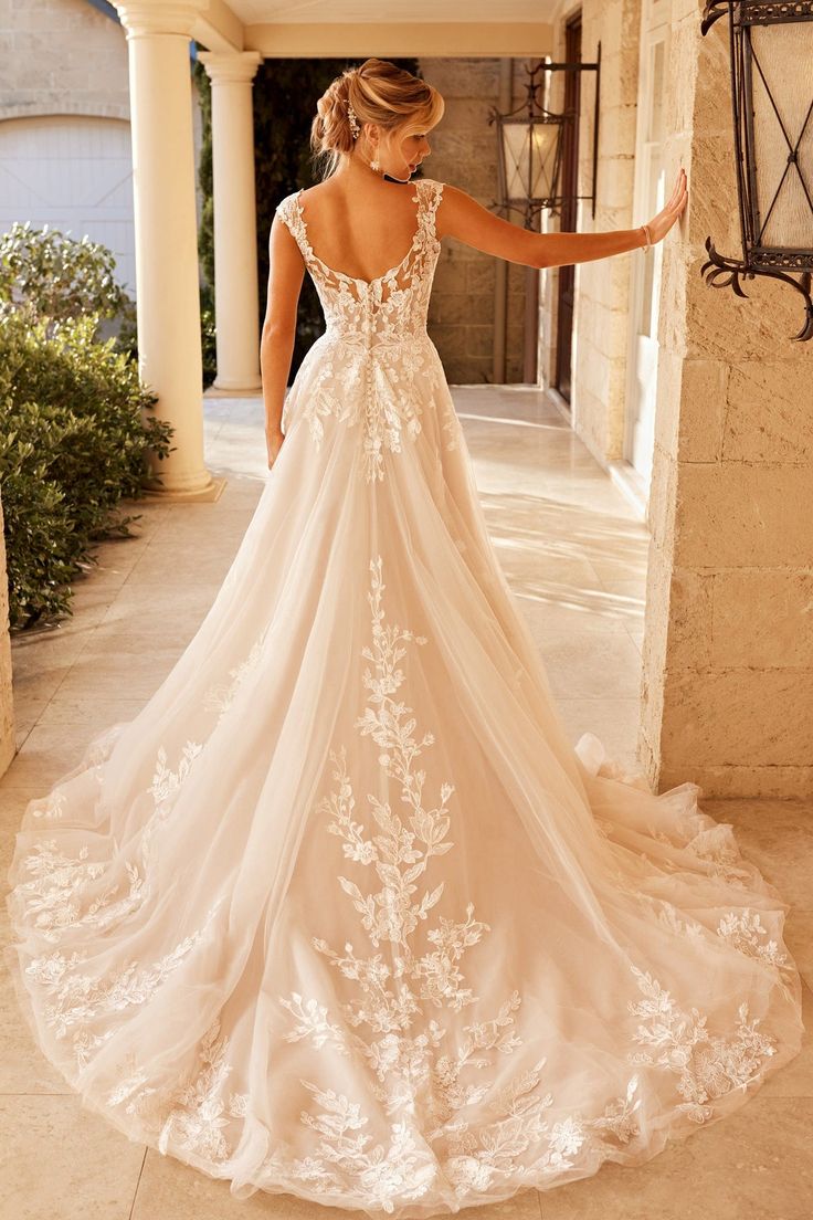 a woman in a wedding dress is standing on the porch with her back to the camera