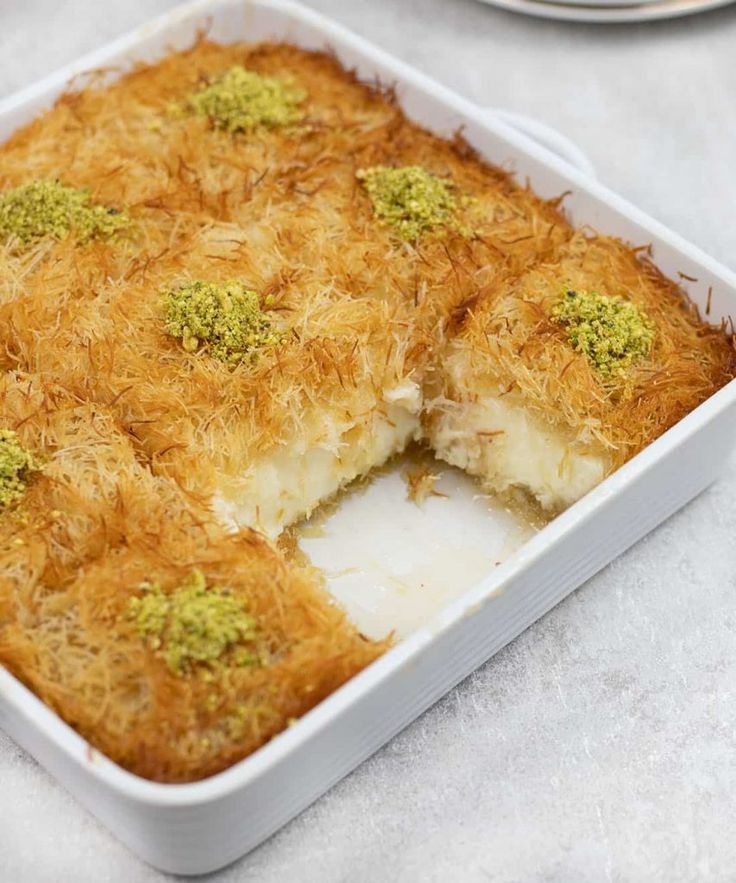 a casserole dish with cheese and broccoli in it on a table