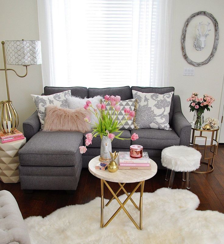 a living room filled with lots of furniture and flowers on top of a coffee table