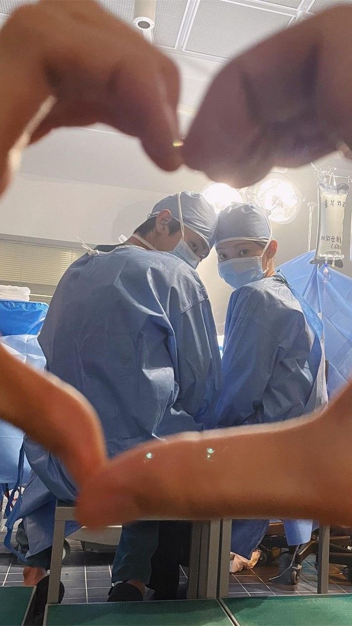 several doctors in scrubs are doing surgery on someone's arm with their hands