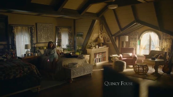 a woman sitting in a bedroom next to a fire place