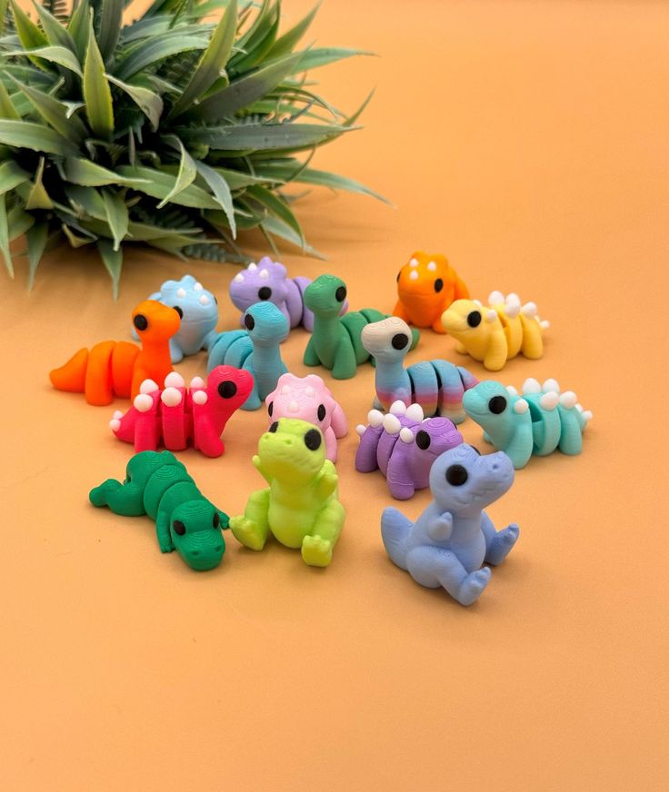 there are many small toy animals next to a pineapple plant on the table with it's leaves