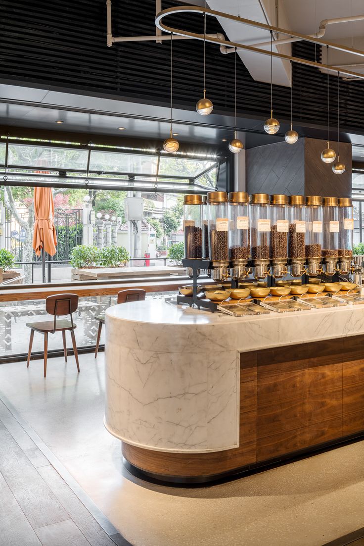 a large counter in a restaurant with lots of lights hanging from it's ceiling