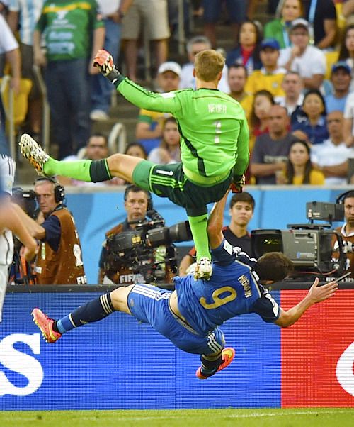 a soccer player is jumping in the air to kick the ball while people watch from the sidelines