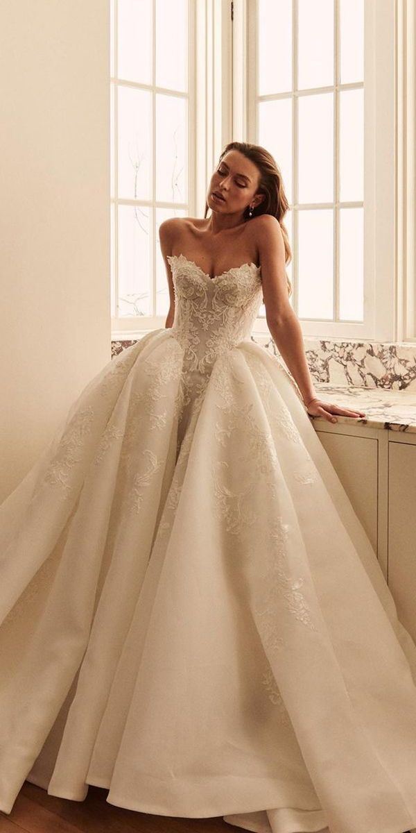 a woman in a wedding dress leaning on a window sill