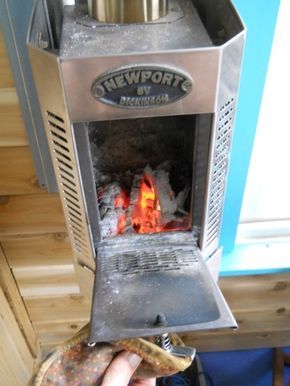 a person is holding up a hot dog in front of an oven with the door open