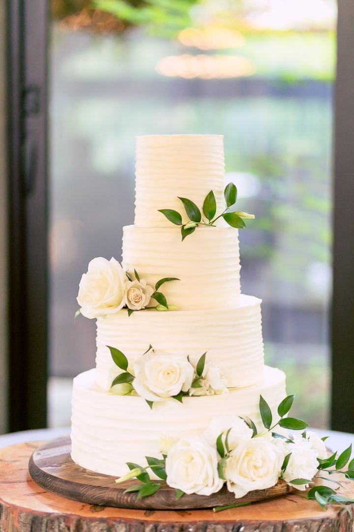 a wedding cake with white flowers and greenery