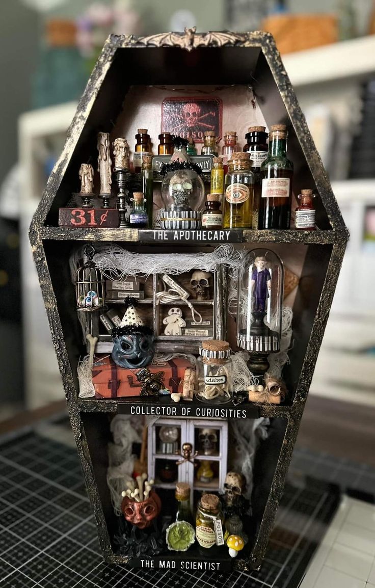 a display case filled with lots of bottles and miniature figurines on top of a table